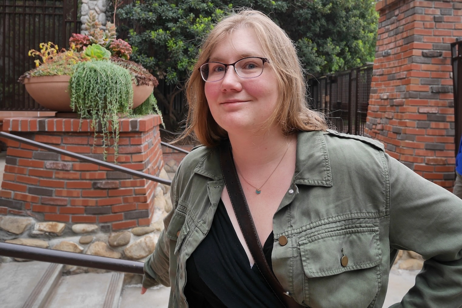 Photograph of the artist: woman with glasses and a green jacket